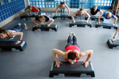 Beden eğitimi sınıfındaki kadınlar spor salonunun merdivenlerinde tahtada. Üst Manzara. Seçili Odaklanma.