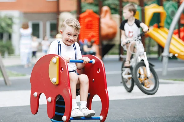 Kleiner Junge Fährt Auf Karussell Auf Spielplatz — Stockfoto