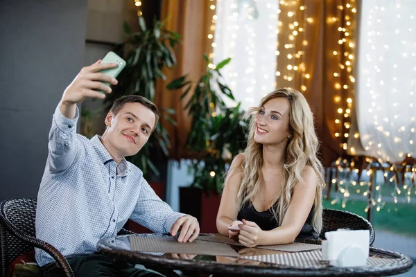 Young Couple Table Cafe Man Makes Selfies Smartphone Selective Focus — Stock Photo, Image