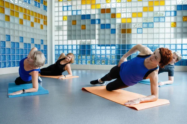 在健身房里 女人用一只胳膊在瑜伽或健身垫上做侧板 — 图库照片