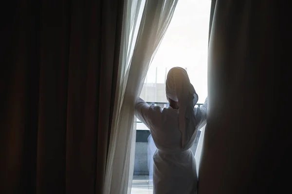 Kobieta Ręcznikiem Głowie Rozsuwa Rano Zasłony Pokoju Hotelowym — Zdjęcie stockowe