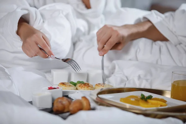 一个留着胡子的男人和一个穿着白衣的女人正在床上吃早餐 有选择的重点 穿上衣服 — 图库照片