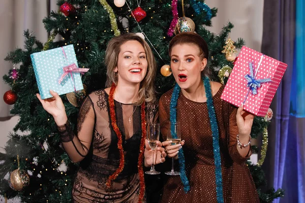 Twee Vriendinnen Geven Elkaar Cadeaudozen Bij Een Kerstboom — Stockfoto