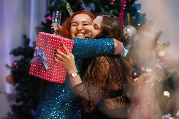 Twee Vriendinnen Geven Elkaar Cadeaudozen Bij Een Kerstboom — Stockfoto