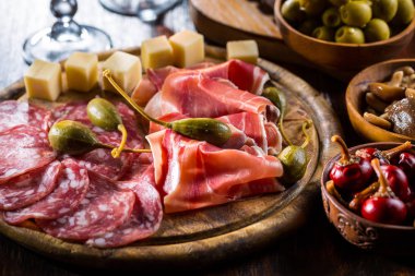 Serrano ham platter with variation of appetizers clipart