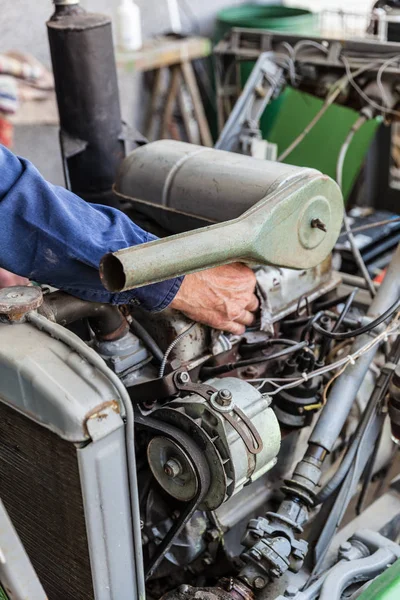 Man repairing old dirty car engine