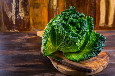 Ahşap arka planda taze çiğ savoy lahanası
