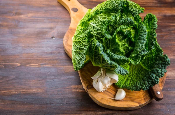 Fresh raw savoy cabbage on wooden background — 图库照片