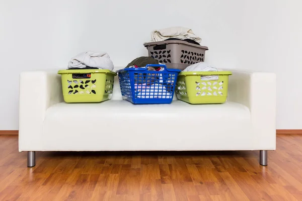 满满一篮子的脏衣服在沙发上 持家概念 — 图库照片