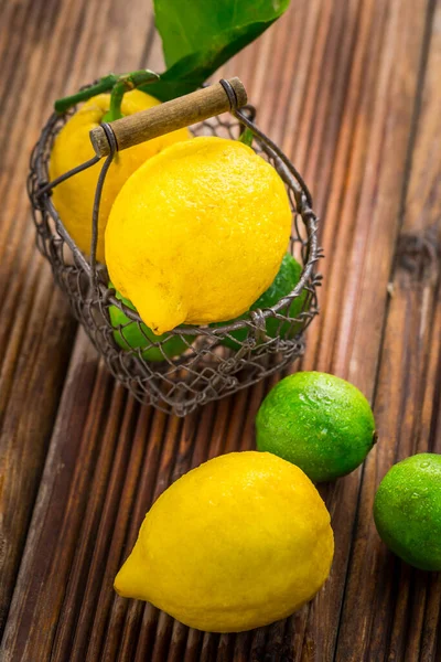 Limones Orgánicos Limas Una Canasta Sobre Fondo Madera —  Fotos de Stock