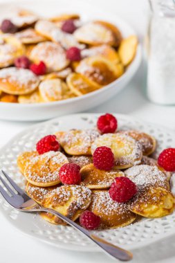 Poffertjes - taze ahududulu küçük Hollanda gözlemeleri. Geleneksel Hollanda mutfağı.