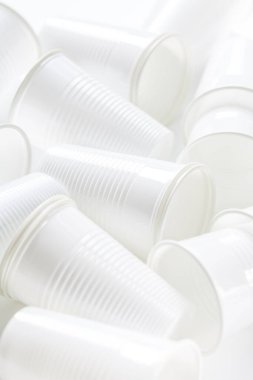 Arka planda tek kullanımlık plastik bardaklar var. Çevresel konsept. Gübrelenmeyen atık.