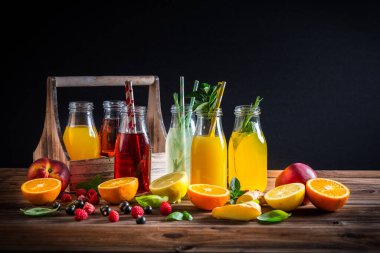 Meyve suyu ve limonata çeşitleri ve ahşap masa üzerinde bitkiler.