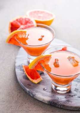 Meyve suyu ile taze pembe greyfurt içeceği. Soğuk yaz turunçgilleri ferahlatıcı içecek ya da buzlu içecekler.