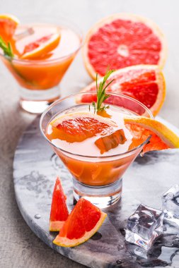 Meyve suyu ile taze pembe greyfurt içeceği. Soğuk yaz narenciye ferahlatıcı içecek ya da biberiyeli içecek..