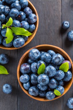 Ahşap arka planda taze organik yaban mersini kasesi. Sağlıklı yiyecek konsepti, sulu vahşi orman meyveleri..