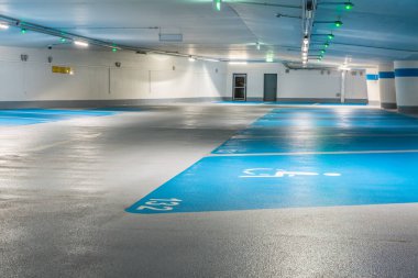 Mavi bir otoparkta engelli park levhası. İşaretlere odaklan.