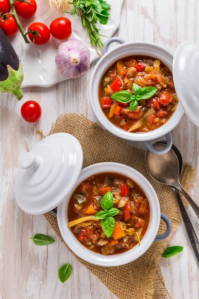 材料の入った小さな鍋で提供されるおいしいイタリアの野菜のミネストローネスープ — ストック写真