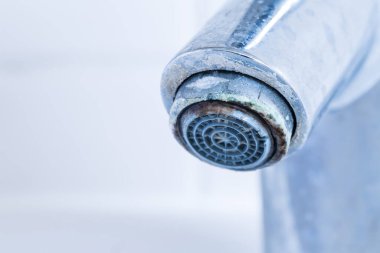 Kireç pullu musluk. Alçalmadan önce kirli ve kireçlenmiş banyo musluklarının ayrıntıları.