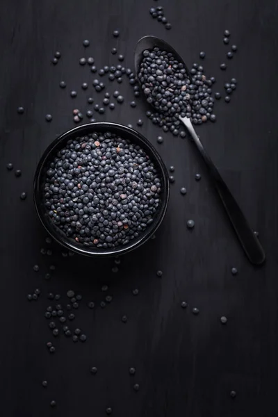 黒を基調としたベルーガレンズ スプーン付きのボウルに黒レンズ豆 — ストック写真