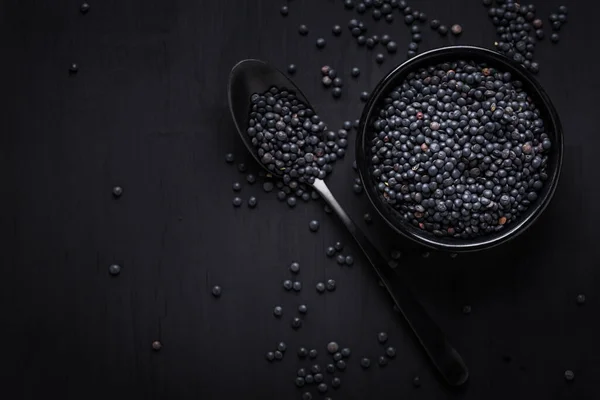 黒を基調としたベルーガレンズ スプーン付きのボウルに黒レンズ豆 — ストック写真