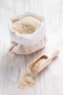 Masanın üzerinde küçük bir torba dolusu psyllium kabuğu var. Psilyum kabuğu, Hindistan 'da bulunan bitki yumurtası bitkisinin tohumlarından elde edilen liftir..