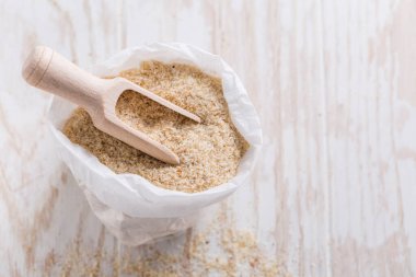 Masanın üzerinde küçük bir torba dolusu psyllium kabuğu var. Psilyum kabuğu, Hindistan 'da bulunan bitki yumurtası bitkisinin tohumlarından elde edilen liftir..
