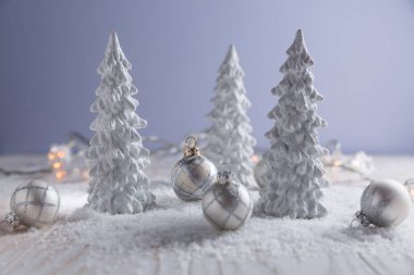 Karlı bir manzara gibi küçük Noel topları olan beyaz ağaçlar. Noel süslemesi.
