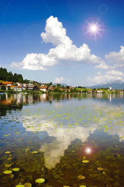 Vista ampla ângulo para alpes gama de montanhas espelhamento no lago Forggensee na região Allgaeu, na Baviera — Fotografia de Stock