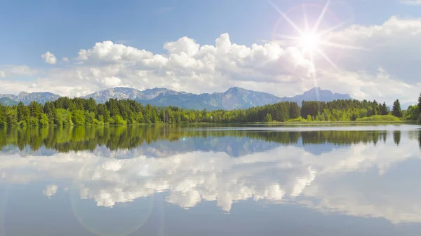 Weitwinkelblick auf die Alpen im Spiegel des Forggensees im Allgäu in Bayern — Stockfoto