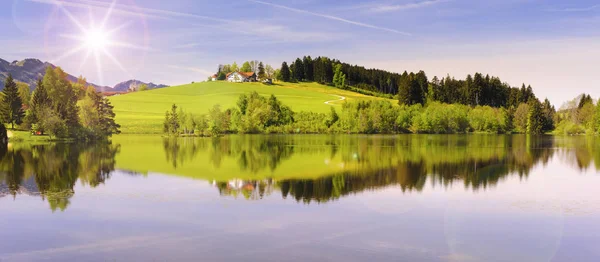 Vista ampla ângulo para alpes gama de montanhas espelhamento no lago Forggensee na região Allgaeu, na Baviera — Fotografia de Stock