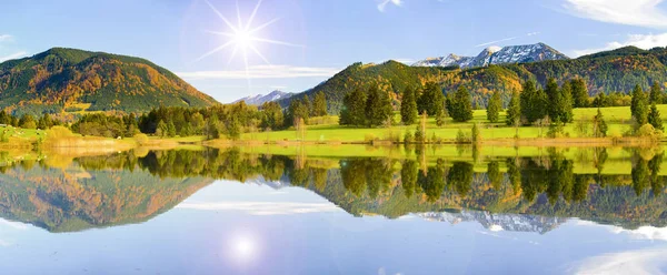 Vidvinkel vy till Alperna bergskedja spegling i sjön Forggensee i regionen Allgaeu i Bayern — Stockfoto