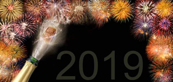 Botella de champán con corcho volador y fuegos artificiales en Silvester 2019 —  Fotos de Stock