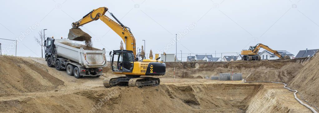 digger and truck working in excavation pit