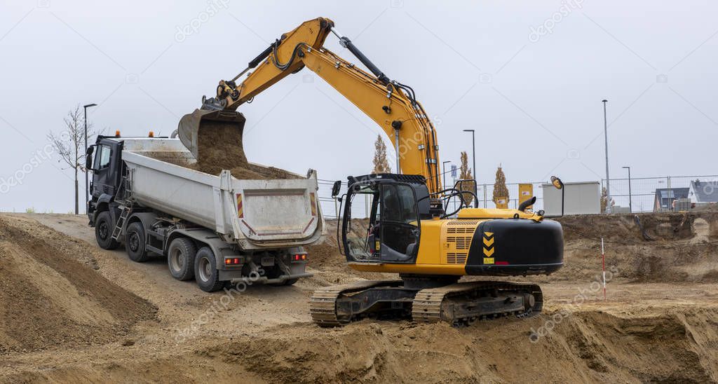 digger and truck working in excavation pit
