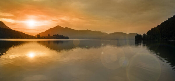  beautiful sunset at lake with mountain range