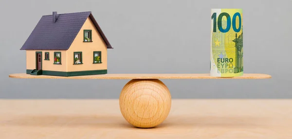 model house and finance in balance
