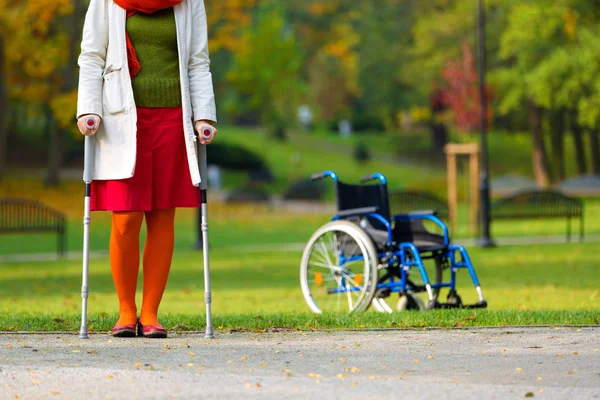 Kvinna Som Tränar Kryckor Grön Park Och Rullstol Stående Bakgrunden — Stockfoto