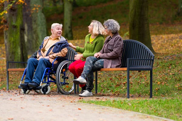 Familjen Parken Sitter Bänk Med Mannen Rullstolen Och Talar — Stockfoto