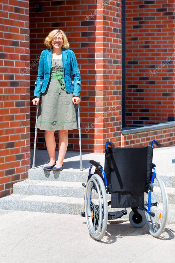 handicapped young woman going down the stairs by herself using crutches