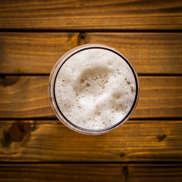 木桌上的一杯啤酒 — 图库照片