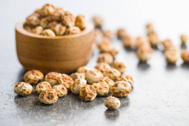 Tiger nuts. Tasty chufa nuts. Healthy superfood on old kitchen table. clipart
