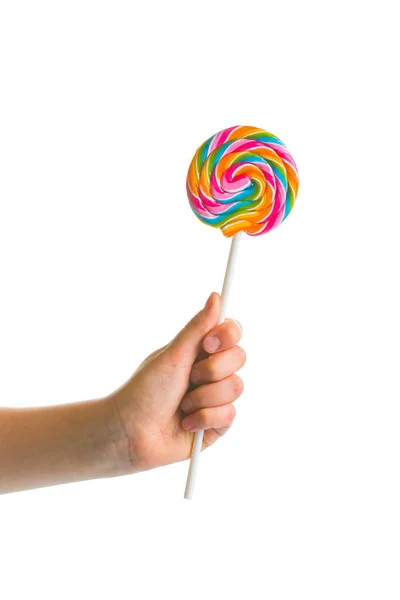 Swirl colorful lollipop in child hand. — Stock Photo, Image