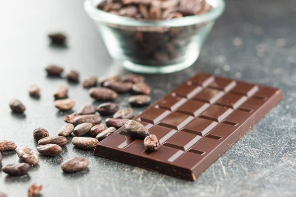 Barra di cioccolato fondente e fagioli di cacao . — Foto Stock
