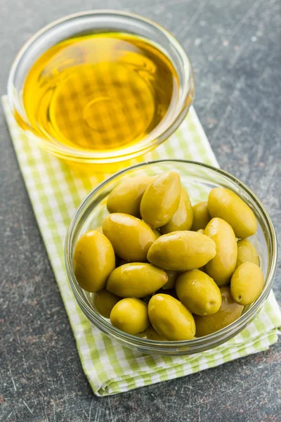 Aceitunas verdes y aceite de oliva en un recipiente de vidrio. —  Fotos de Stock