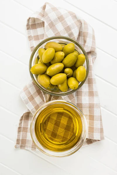 Oliwki zielone i oliwa z oliwek w szklanej misce. — Zdjęcie stockowe