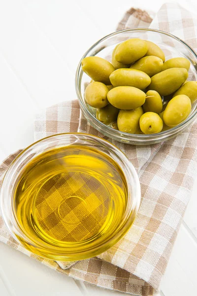 Gröna oliver och olivolja i glasskål. — Stockfoto