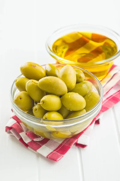 Gröna oliver och olivolja i glasskål. — Stockfoto