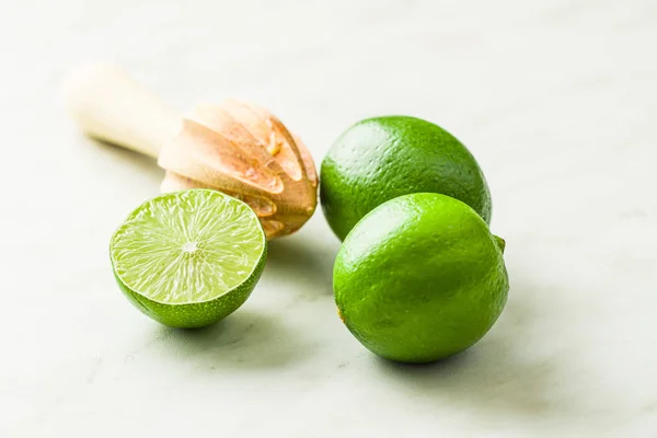 Exprimidor de cítricos de madera y cal verde. —  Fotos de Stock