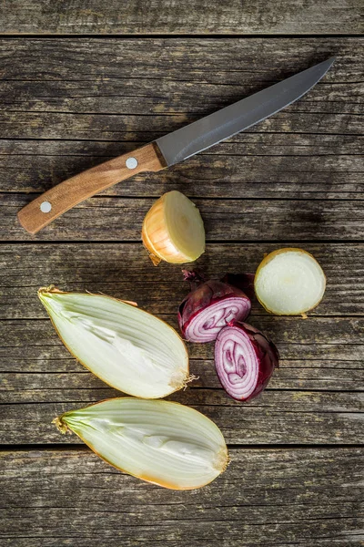 Bombillas frescas a la mitad. Cortar cebollas y cuchillo . — Foto de Stock